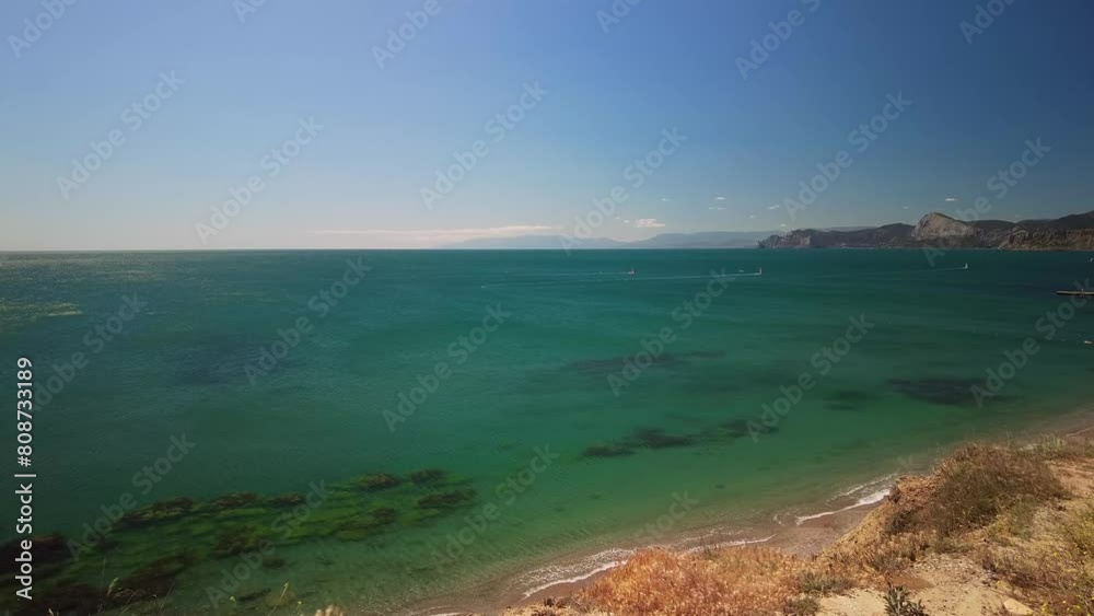 Crimea, Cape Megan, surfers with a sail cut through the green water of the Black Sea in warm spring Crimea, Cape Megan, surfers with a sail cut through the green water of the Black Sea in warm spring