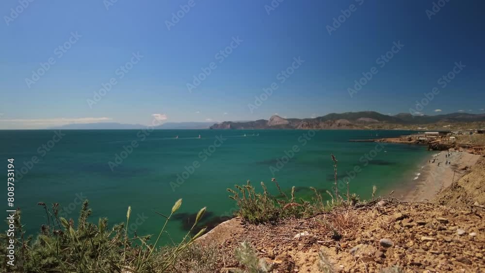 Crimea, Cape Megan, surfers with a sail cut through the green water of the Black Sea in spring Crimea, Cape Megan, surfers with a sail cut through the green water of the Black Sea in spring