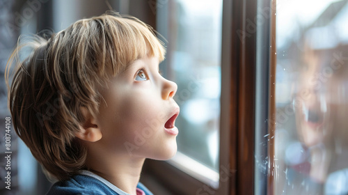 a boy looking out the window surprised