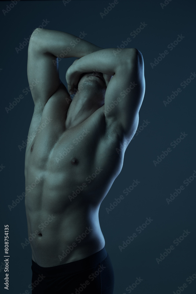 Bodybuilder man, stretching and muscle in studio for wellness, healthy body or art deco on black background. Male person, fitness and performance or power for health while masculine and sensual Bodybuilder man, stretching and muscle in studio for wellness, healthy body or art deco on black background. Male person, fitness and performance or power for health while masculine and sensual