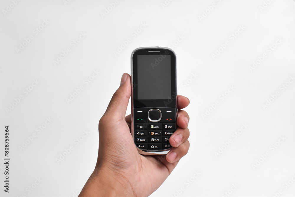 Hand holding Old Mobile Phone isolated on white background. Old cellular mobile phone Hand holding Old Mobile Phone isolated on white background. Old cellular mobile phone