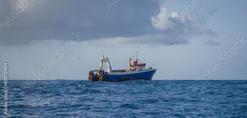 Fishing vessel during the industrial harvesting of wild marine products by deep-sea trawl.