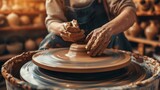 A creative woman skillfully shapes a clay pot on a spinning potters wheel, her hands expertly crafting a unique piece of art