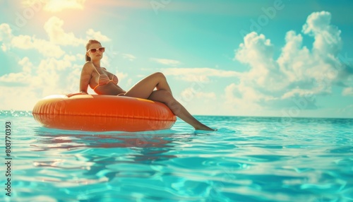 Woman relaxing on pool float in sunlit water © Minerva Studio