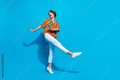 Full body photo of carefree satisfied lady have good mood dancing empty space isolated on blue color background