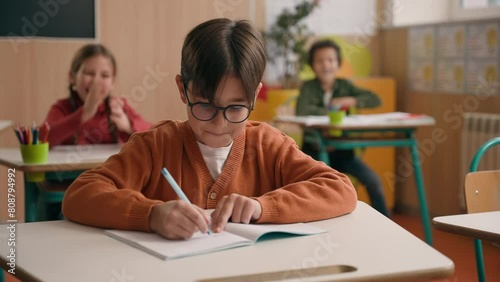 Caucasian little boy kid schoolboy nerd in glasses write task class lesson school education angry children cruel throw crumpled paper balls abuse abusing bullying classmates studying problem mock