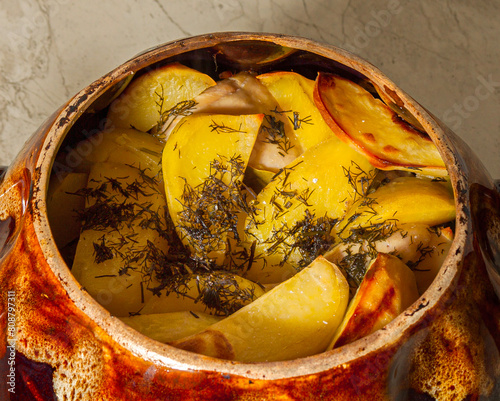 Potatoes baked in a cauldron. The chef prepares fried potatoes in a wood-burning oven in nature. Decorated with greenery. Close-up. food on a round plate.