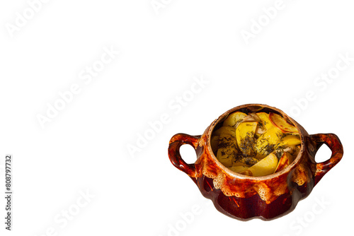 Potatoes baked in a cauldron.On a white isolated background. The chef prepares fried potatoes in a wood-burning oven in nature. Decorated with greenery. Close-up. food on a round plate.