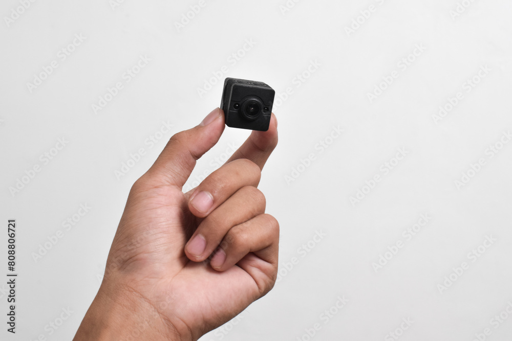 Hand holding a spy camera isolated on white background. Black security camera, Mini spy camera Hand holding a spy camera isolated on white background. Black security camera, Mini spy camera