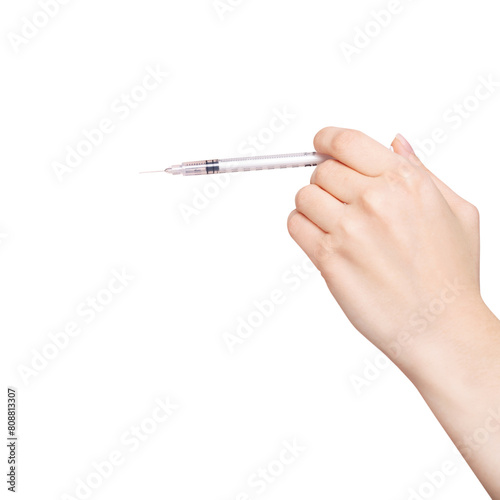 Female hand holds a syringe.