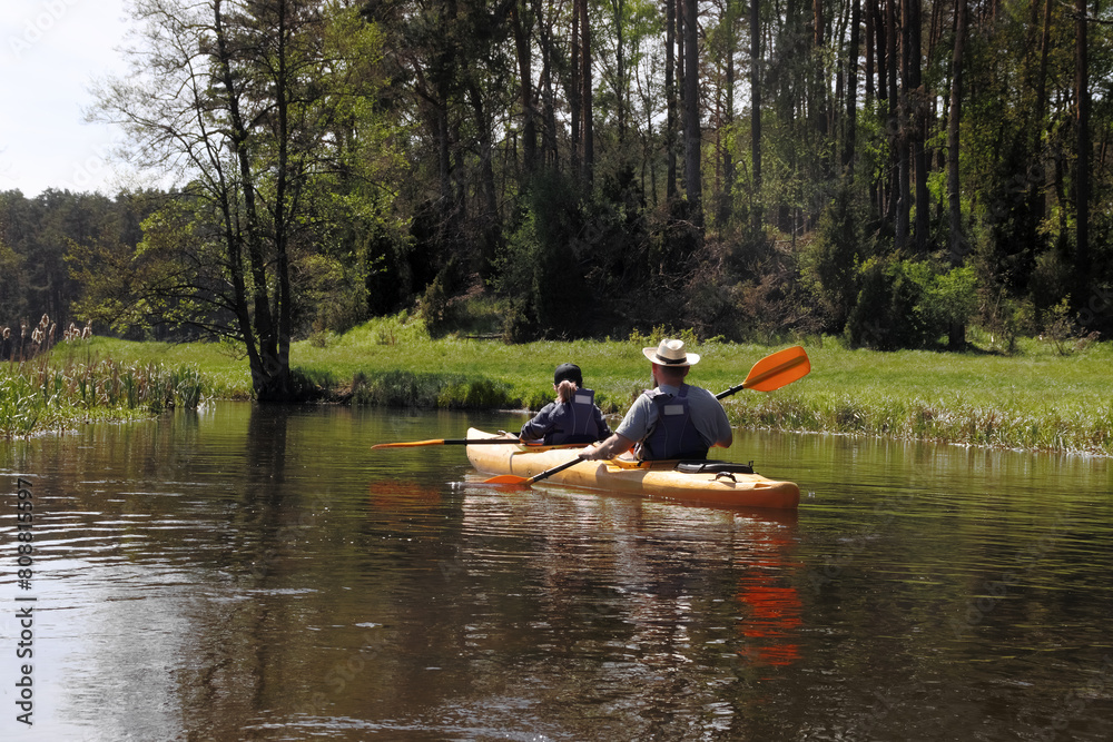 Man and girl in kayak  on  river.