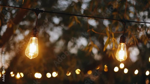 Close-up of evening light bulbs with warm light illuminating the space. Decoration of the evening courtyard photo