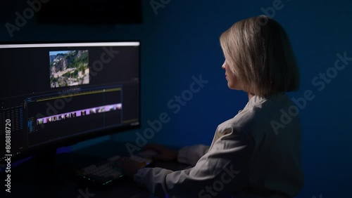 Focused female videography expert editing video footage, improving montage quality on creative software. Professional movie editor highlights, selects and moves footage in timeline editing project.