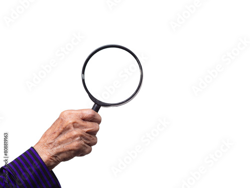 Close-up of an old woman's hand holding a magnifying glass against a transparent background.