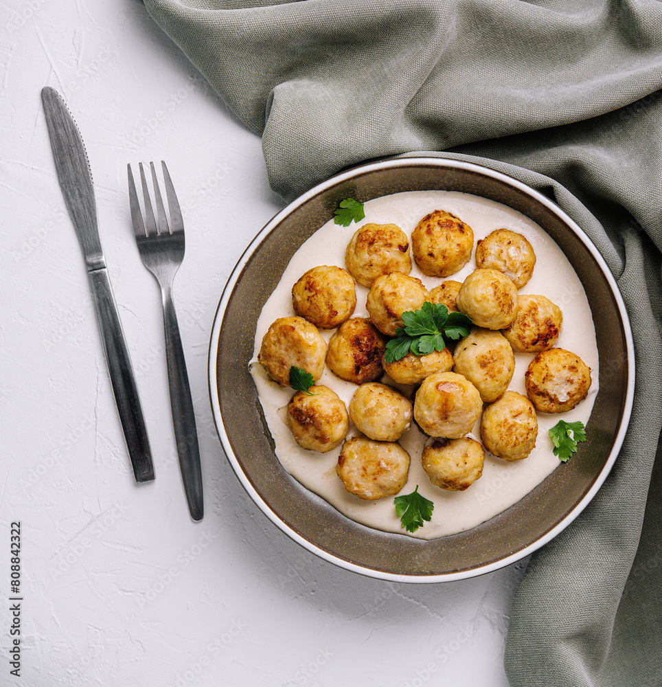 Homemade meatballs stewed in cream sauce on elegant dinner table Homemade meatballs stewed in cream sauce on elegant dinner table
