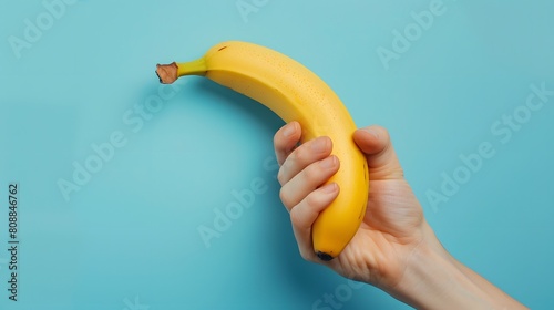hand holding a ripe banana on a blue background