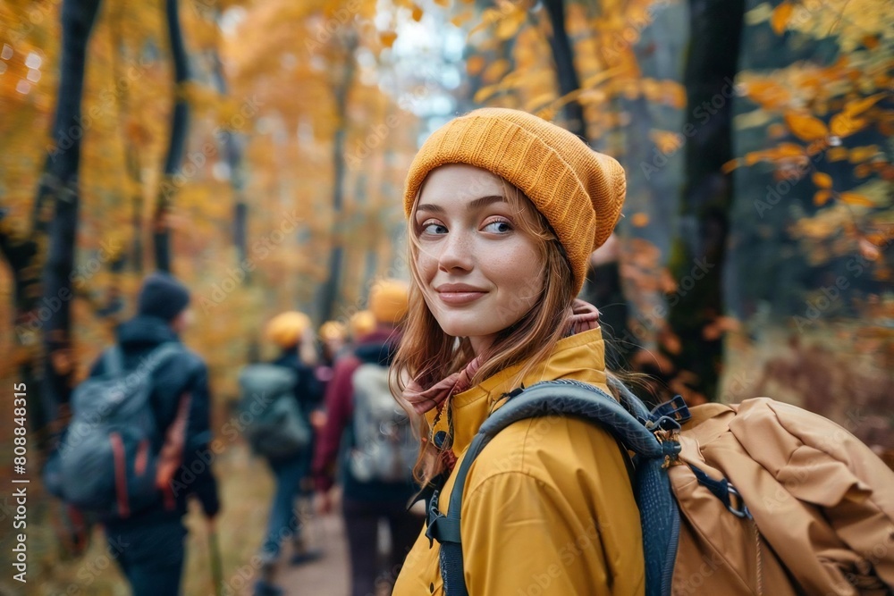 Young Caucasian Woman Explores the Autumn Forest: Trekking through Nature with a Group of Tourists