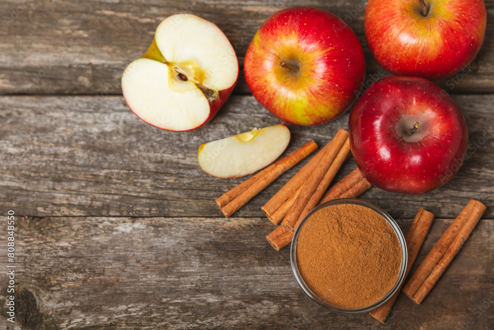 Apples with cinnamon on a textured wooden background. Fragrant red spiced apples with cinnamon sticks and star anise. Apple slices with spicy spices. Place for text. Copy space. Harvesting. Fruits. Apples with cinnamon on a textured wooden background. Fragrant red spiced apples with cinnamon sticks and star anise. Apple slices with spicy spices. Place for text. Copy space. Harvesting. Fruits.