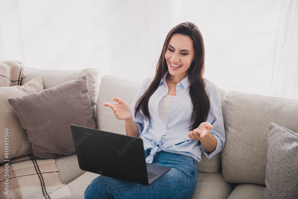 Portrait of pretty lady speak video call laptop wear shirt bright interior apartment indoors Portrait of pretty lady speak video call laptop wear shirt bright interior apartment indoors