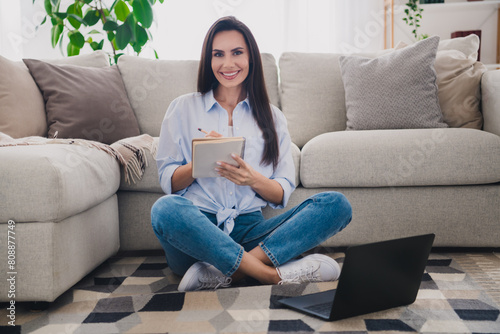 Full size photo of nice lady hold notepad pen use laptop wear blue shirt bright interior flat indoors