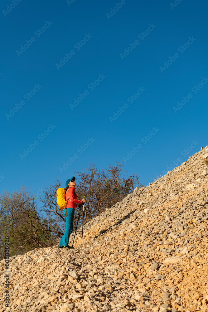 Woman backpacker on the hiking path to Frares de Serrella mountain range on Costa Blanca, Quatretondeta , Alicante, Spain - stock photo