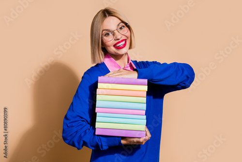 Photo of gorgeous intelligent lady toothy smile arms hold pile stack book isolated on beige color background