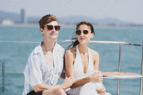 A Smart Happy young adult couple enjoying spending relaxation vacation or weekend time together while watching a sunset sail on a yacht. Romantic and Honeymoon wellbeing, Luxury and elegance lifestyle © chokniti