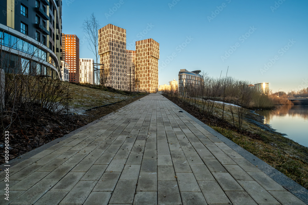 A stone pedestrian sidewalk leading to the city buildings.