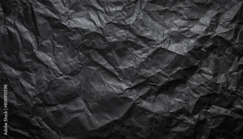 Black crumpled paper texture in low light background