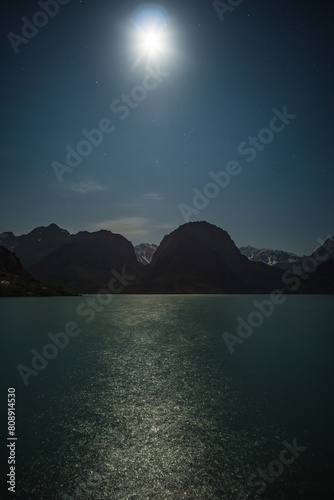 Night landscape panorama of Lake Iskanderkul with the starry sky on a full moon photo