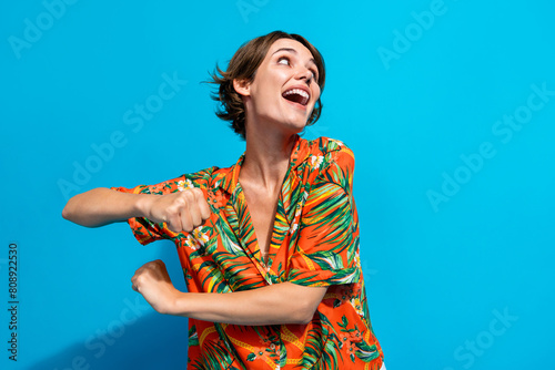 Photo of satisfied overjoyed lady arms make moves dancing chilling free time isolated on blue color background