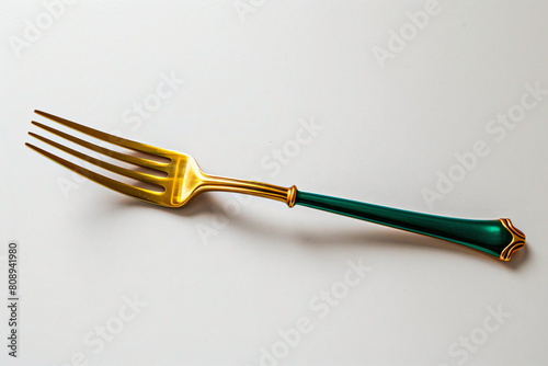 a fork with a green handle on a white surface