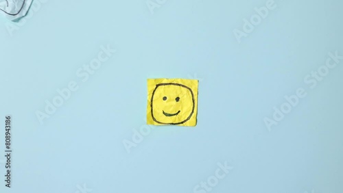 Sad faces on blue stickers and one yellow happy one. Positive sticker, smile sign on background of sad symbols. Concept of success and winning in business.