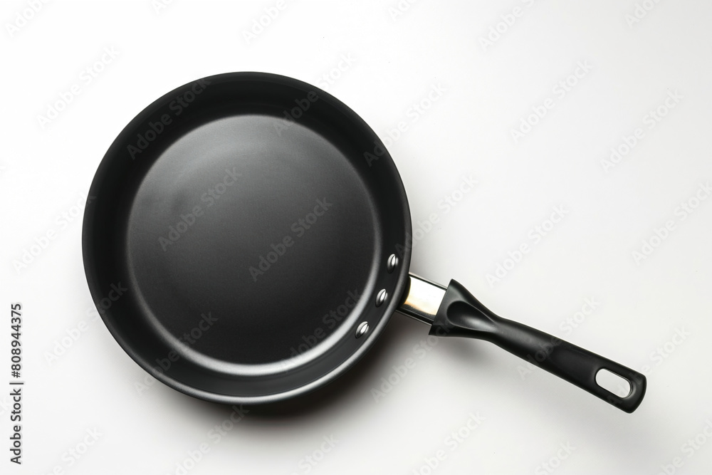 a black frying pan on a white surface a black frying pan on a white surface