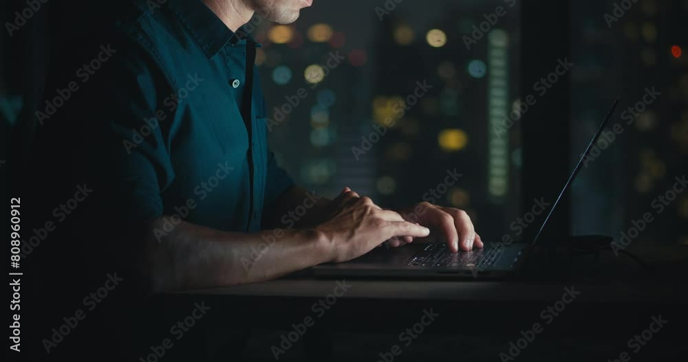 Male person works at computer typing home office close-up on hands programmer writes lines code programming. Person working apartment office programming coding close up to hands night time.