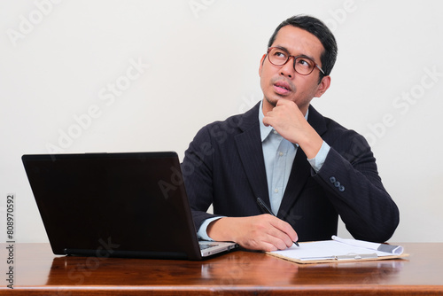 A recruiter staff sitting on his working table thinking about something photo