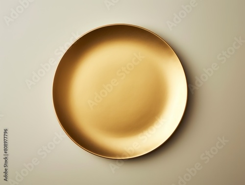 empty gold plate on a beige background 