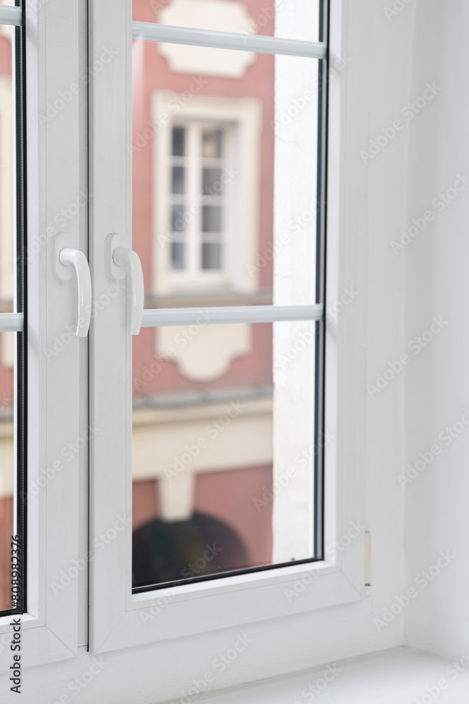 Modern pvc window with double glazing pane, white frame and handles Modern pvc window with double glazing pane, white frame and handles