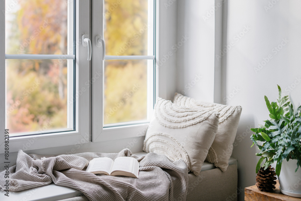 Φωτογραφία Home interior with cozy windowsill with blanket, cushions and paper book in room