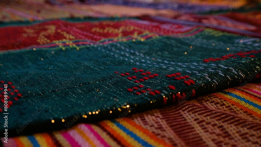 Close up side view handmade woven fabric with unique pattern from Indonesia, selective focus, multicolour textured textile background Close up side view handmade woven fabric with unique pattern from Indonesia, selective focus, multicolour textured textile background