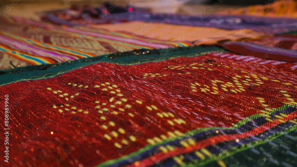 Close up side view handmade woven fabric with unique pattern from Indonesia, selective focus, multicolour textured textile background Close up side view handmade woven fabric with unique pattern from Indonesia, selective focus, multicolour textured textile background