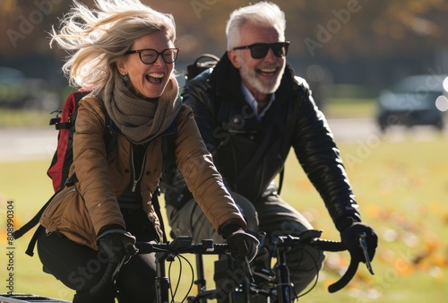 Two people riding bicycles and laughing in the park