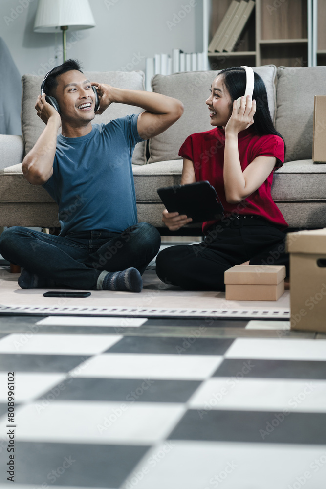 Young couple relaxing sitting on the floor around cardboard boxes at home, smiling happy moving to a new house. Young couple relaxing sitting on the floor around cardboard boxes at home, smiling happy moving to a new house.