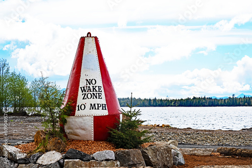 A red and white navigational buoy is repurposed as an attractive speed limit sign at Port Klawock on Prince of Wales island in Alaska.