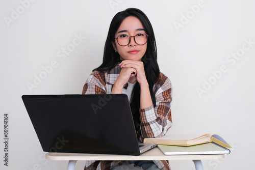 Thoughtful female college student sitting on her study desk