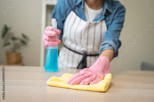 Foto Close-up hand of maid cleaning table during household job.