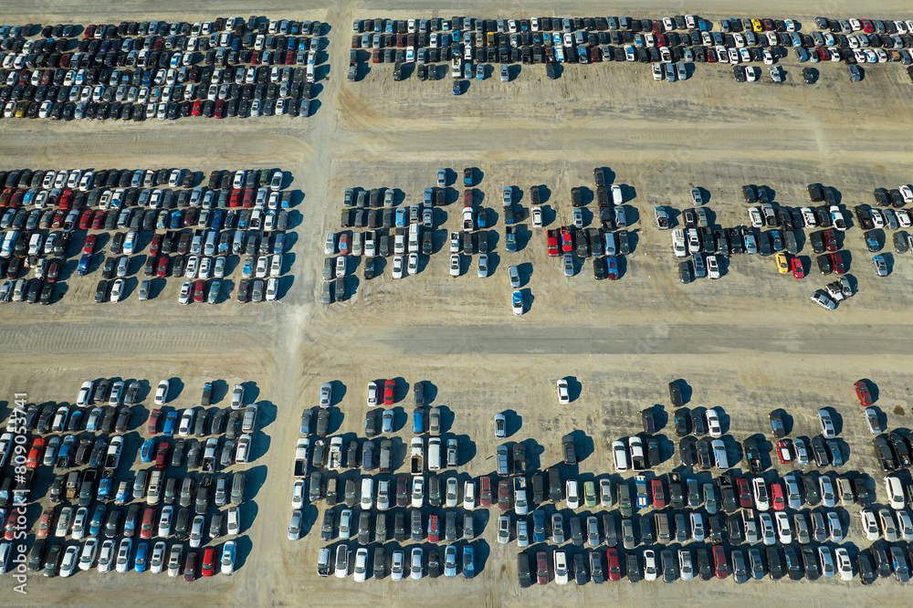 Obraz premium Aerial view of auction reseller company big parking lot with parked cars ready for remarketing services. Sales of secondhand vehicles