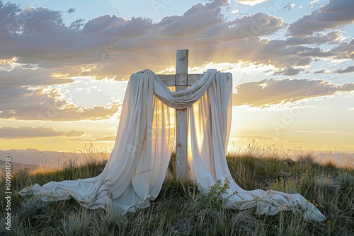 Wooden cross artwork adorned with luxurious white cloth, glowing in enchanting sunset photo