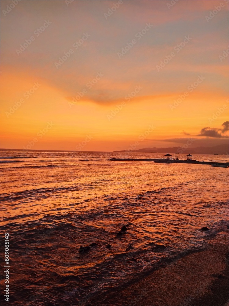 Golden sunset on the island of Bali, ocean shore, sky, surf, clouds, sandy beach