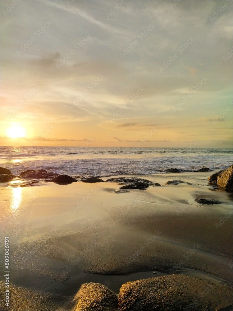 Yellow-orange sunset and sunrise on the ocean shore, Bali island. Epic sunrise, sandy beach. Landscape of Indonesia Yellow-orange sunset and sunrise on the ocean shore, Bali island. Epic sunrise, sandy beach. Landscape of Indonesia